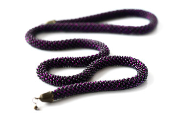Long beaded rope purple color isolated on white background close up