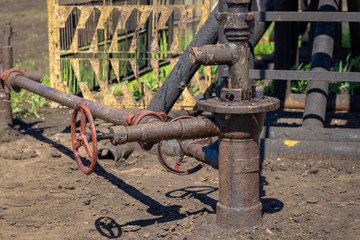 Oil and gas processing plant with pipe line valves. Oil pipeline valves in the oil and gas industry. Valve plug an oil pipeline in the field on a sunny summer day.