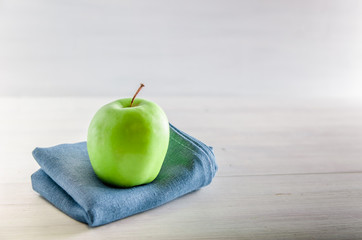 green apple on a white wooden background