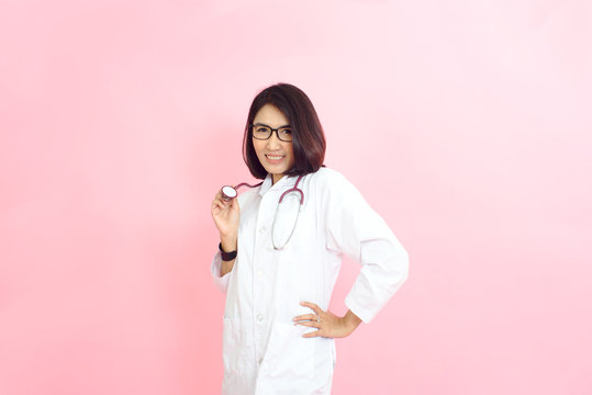 The photo of a beautiful Asian doctor smiling brightly with a pink background