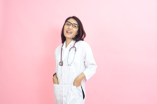 The photo of a beautiful Asian doctor smiling brightly with a pink background