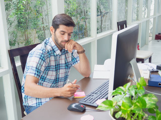 young man working at home and thinking something ,businessman works on his computer to get all his business