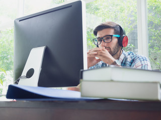 young man relax at home with earphone ,businessman works on his computer to get all his business