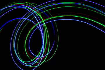 Long exposure, light painting photography.  Vibrant streaks of neon multi color against a black background.