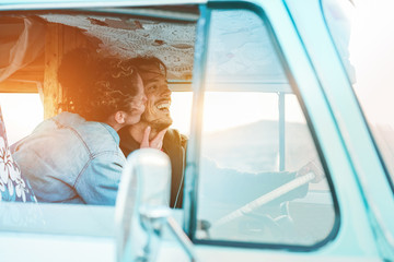 Happy couple inside minivan doing a road trip - Woman with freckles having fun on summer vacation...