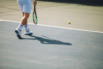 Tennis player walking on the hard court