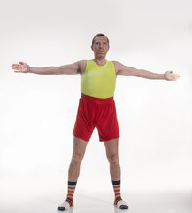 Funny man in bright shorts doing sports on a white background