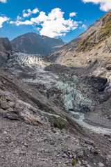 Hiking through the barren and rugged landscape that leads to the head of Franz Josef Glacier in New Zealand