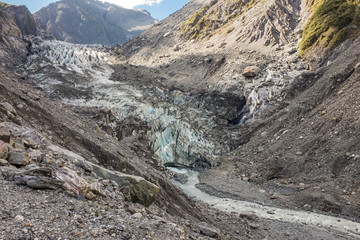 Hiking through the barren and rugged landscape that leads to the head of Franz Josef Glacier in New Zealand