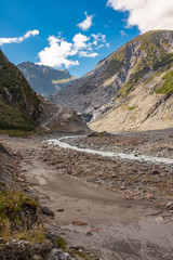Hiking through the barren and rugged landscape that leads to the head of Franz Josef Glacier in New Zealand