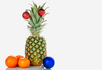 Fototapeta na wymiar Pineapple, tangerines, Christmas toy on a white background