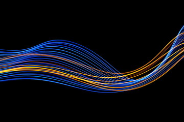 Long exposure, light painting photography.  Vibrant streaks of neon blue and gold color against a black background.