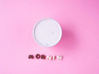 cereal breakfast bowl with yogurt and cherry on pink background top view