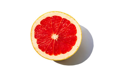 Half of ripe grapefruit isolated on white background. Minimal flat lay concept.