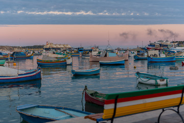Fototapeta premium Traditional eyed colorful boats Luzzu in the Harbor of Mediterranean fishing village Marsaxlokk, Malta