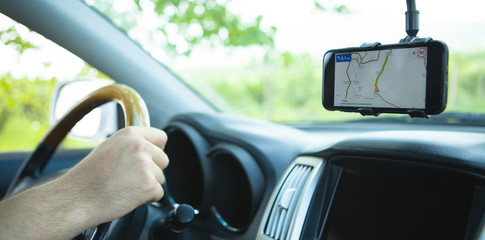 The driver uses a mobile smartphone with a GPS map navigation application.