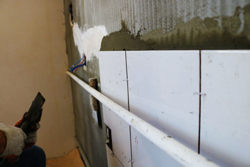 Repair concept. Ceramic tiles. The master lays ceramic tiles on the wall	