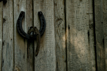 rusty horseshoe hanging on a wooden wall from boards