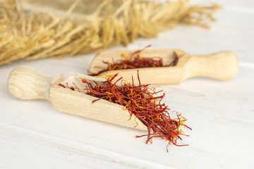 Lot of whole dry shaffron thread in two scoops and jute cloth on white wood