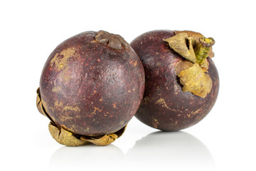 Group of two whole fresh deep purple mangosteen isolated on white background