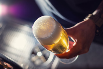 glass of craft beer in bartender hand closeup