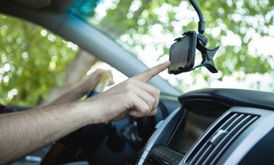 The driver uses a mobile smartphone with a GPS map navigation application.