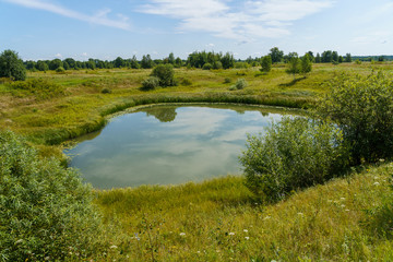 round lake among floodplain meadows and forests