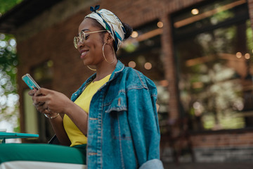 Young adult afro-american woman looking on smartphone