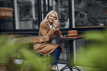 Pleased woman with coffee looking happy stock photo