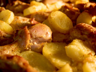 Appetizing chicken with baked potatoes in oven