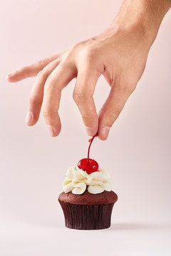 Cupcake decoration. Hand decorating cupcake adding cherry on top. Stock  Photo | Adobe Stock