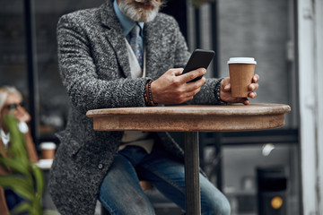 Hands of man with smartphone and coffee stock photo