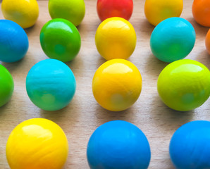 colored toy balls on a wooden table. educational toys for children. background for business