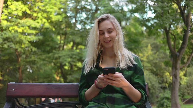 beauty caucasian woman sitting at park use smartphone nature social media 5g