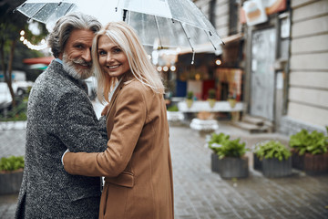 Smiling couple enjoying rainy day stock photo