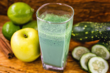 Green detox juice, kale leaves, lemon, apple, lettuce, cucumber, lime and other green vegetables. Copy space. Vegetarian juice, alkaline food concept. Healthy life. Copy space Raw, vegan, vegetarian.
