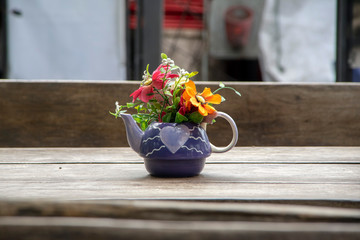 Teapot and plastic flowers as table decoration, Chiang Mai, Thailand
