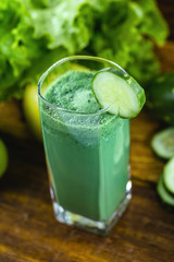 Green smoothie with ingredients on wood table, healthy food concept. Diet or regimen concept.