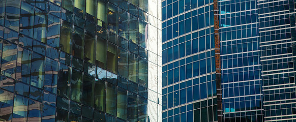 part of the facade of a glass skyscraper. The city's modern architectural background