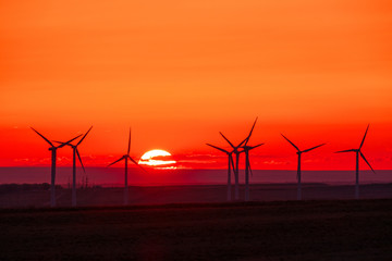 Fototapeta na wymiar Wind turbines on the background of golden sunset.