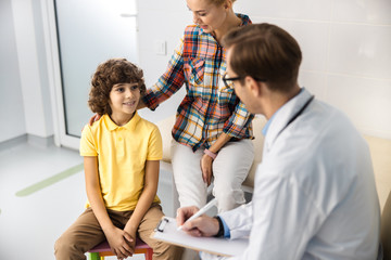 Obraz premium Happy kid listening to doctor stock photo