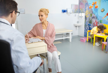 Obraz premium Woman visiting physician with son stock photo