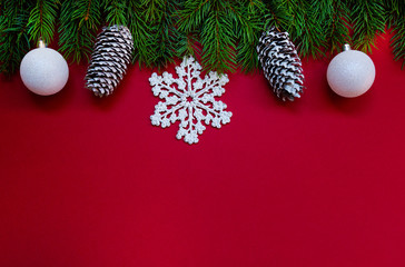 Christmas composition. Fresh fir tree branches, decorations on red background. Christmas, winter, new year concept. Flat lay, top view, copy space.