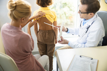 Physician checking boy back problems stock photo