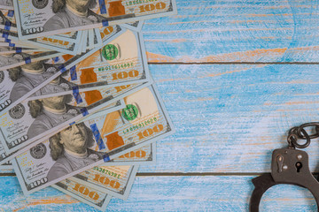 Handcuffs for the arrest of criminals, us dollar bills on a financial crimes, corruption.