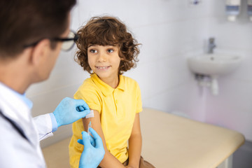Cheerful kid visiting clinic for injection stock photo