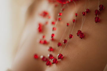 Red jewelry on woman chest close-up