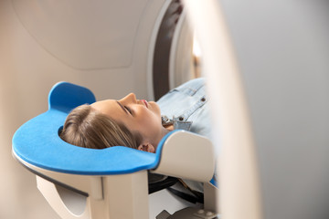 Young woman having CT scan at modern hospital