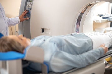 Obraz premium Doctor pressing button on CT scan machine