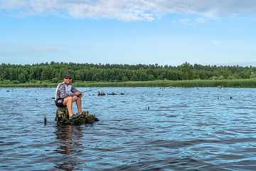 Fishing. Fisherman in action, lonely man catch fish by spinning rod